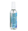 RFSU Toy Cleaner; kirkas 100 ml:n lieriön muotoinen suihkepullo valkoisella muovikorkilla, sekä pullo että korkki kiiltäväpintaisia; sininen etiketti alaosassa kääriytyy mattapintana, tiheä groteskitekstin asettelu; kierrätys- ja käyttösymboleja sekä monikielistä tekstiä; vaalea tausta tasaisessa valaistuksessa.