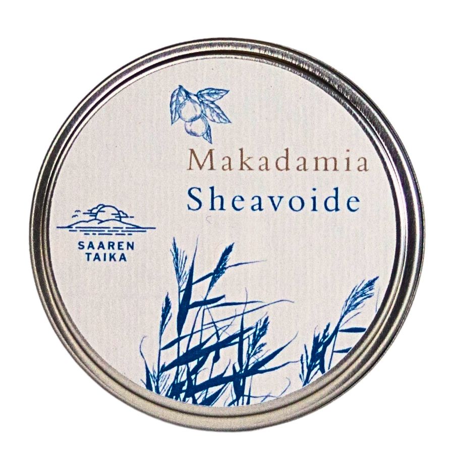 A round tin labeled Makadamia Sheavoide with blue illustrations of grass and a macadamia nut. The text SAAREN TAIKA appears below a wave and sun icon. Matte-finish, smooth metal container with an off-white label, simple sans-serif typography. Product is photographed front-facing on a plain, neutral background with no people or hands visible.