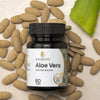 Saharogya Aloe Vera 750 mg; pullo, 60 tablettia, valkoinen muovipurkki vihreällä korkilla ja mattapinnalla pystyssä; etiketissä "Saharogya" lihavoidulla groteskifontilla ja "Aloe Vera" selkeästi alla; valkoisia pyöreitä tabletteja siroteltuna lähelle sekä pätkä vihreää aaloelehteä vaaleansävyisellä tekstuuripintaisella taustalla, laakakuva.