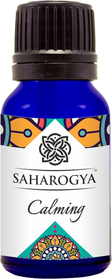 A blue glass bottle labeled “SAHAROGYA Calming” with a black screw cap. The bottle has a cylindrical shape with a glossy finish. The label displays multicolored, decorative patterns and contains the product name in clear, sans-serif font. The image is a product shot against a plain white background. No people or hands are present.