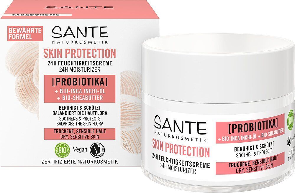 Sante Skin Protection 24h Kosteusvoide; pyöreä purkki vaaleanpunaisella mattakannella ja valkoisella pohjalla, yhdistettynä sopivaan vaaleanpunavalkoiseen suorakulmaiseen laatikkoon; pakkauksessa mustaa ja vaaleanpunaista groteskikirjasinta; sekä purkissa että laatikossa tuotenimi ja pääainesosat; tausta valkoinen, ei ihmisiä tai käsiä näkyvissä