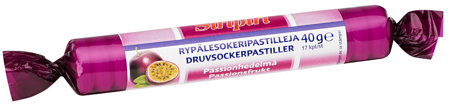 A roll of Surpri passion fruit flavored dextrose pastilles, 40g package, wrapped in vibrant purple packaging featuring a passion fruit illustration on the label. The wrapper has a glossy finish and is cylindrical. Label text includes the brand name and flavor in bold sans-serif font. No people or hands visible. Background is plain white, photographed from above with full product in frame.