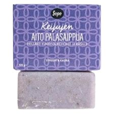 A purple bar of soap with a matte finish sits below a matching rectangular box. The box is labeled “Keijujen Aito Palasaippua” in Finnish and displays a black “Sopo” logo in bold, rounded letters at the top. The box features a dense, decorative pattern in complementary colors. No people or hands are present; the shot has a neutral background.