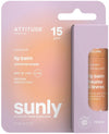 Sunly by Attitude Huulivoide SPF15; persikan- ja violetinvärinen pakkaus ATTITUDE Sunly -kookoshuulivoidetta, SPF 15, keskitasoinen suoja, vegaaninen ja muovivapaa, tuote osittain näkyvissä sivuikkunasta; pakkauksessa korostetaan laajakirjoista UVB+UVA-suojaa; laatikko mattapinnalla ja suorakulmainen; lihavoitu groteskikirjasin kontrastivärein; ei ihmisiä tai rekvisiittaa kuvassa, pelkistetty tausta, lähikuva.