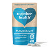 Together Health Magnesium; sininen-beige pussi tekstillä "Magnesium... From Mineral Salts" pystyssä; mattapintainen, taipuisa ja suorakulmainen pussi saumattavalla yläosalla; sekoitus valkoista, vaaleansinistä ja laivastonsinistä groteskitekstiä; kolme luonnonvalkoista kapselia pussin edessä valkoisella alustalla.