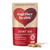 Together Health Joint Aid; punainen-beige pahvipakkaus pyöristetyin kulmin, sisältää kurkumiinia ja boswelliauutetta; valkoista ja kultaista groteskitekstiä; kaksi läpikuultamatonta beigeä kapselia pakkauksen edessä; valkoinen tausta.