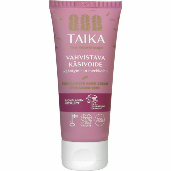Vaaleanpunainen Taika-käsivoideputkilo, merkitty Vahvistava Käsivoide for aging skin, pehmeää mattamuovia kierrekorkilla; etiketissä kuvakkeita vegaanisuudesta, eläinkokeettomuudesta, ei mikromuoveja ja Cosmos Natural -sertifikaatista; typografia valkoista ja groteskia; tausta valkoinen; ei ihmisiä tai käsiä näkyvissä kuvassa.