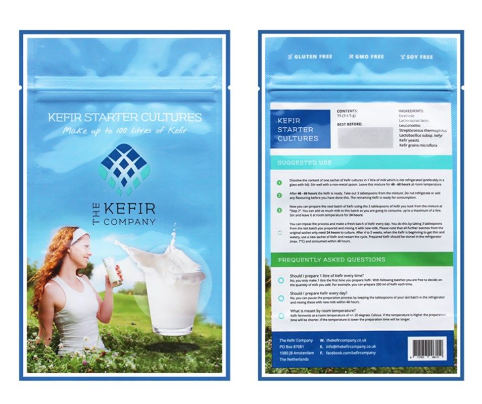 Front and back of a blue Kefir starter cultures package, featuring a woman drinking a glass of kefir outdoors. Matte finish pouch with rounded corners. Legible text includes product details, instructions, FAQs, ingredient lists, and information about live cultures. Serif and sans-serif fonts appear in contrasting white and dark blue. White outdoor background in the main image.