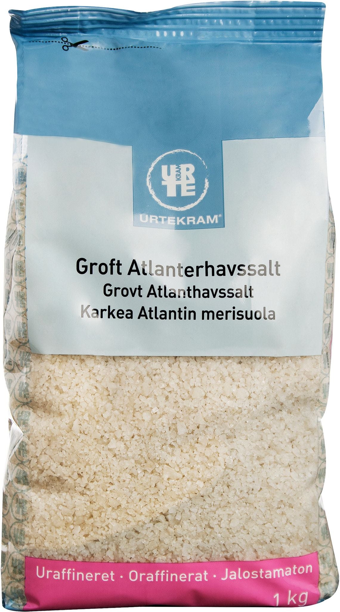 A 1 kg bag of Urtekram coarse Atlantic sea salt with multilingual labeling in Danish, Norwegian, and Finnish. The unrefined sea salt is visible through a transparent plastic bag sealed with a blue matte-finish top. The label uses sans serif font with dark text on a white background. Product rests against a plain white backdrop; no people or extra objects are present.