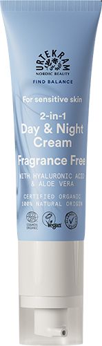 A tube of Urtekram Nordic Beauty 2-in-1 Day & Night Cream for sensitive skin, fragrance free, enriched with hyaluronic acid and soothing aloe vera. The blue and white plastic tube has a matte finish, upright shape, and displays product name in bold sans-serif font. Organic certification logos are visible near the base. No people or setting are present; plain background.