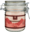 A glass jar of Urtekram Himalayan salt with a metal clasp lid. The jar is cylindrical and transparent, showing pink salt crystals inside. The label has pink and red colors, displays the brand name “Urtekram,” and notes a net weight of 385 grams. Typography is clean and sans-serif. The surface finish appears glossy. No people or hands are present. White background, product-centered shot.