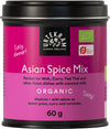 A cylindrical tin with a matte purple and black label is shown. The label includes the text: “A tin labeled Urtekram Asian Spice Mix, 60g, for wok, curry, pad Thai, and other Asian dishes. This organic blend features medium spice with lemongrass, curry, coriander, and a hint of exotic flavor. The label is purple and black.” Sans-serif fonts are used on the packaging. The background is plain white. No people or hands are present in the image.