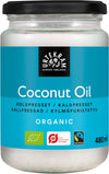 A jar of Urtekram organic coconut oil with a blue label, assorted certifications, and a white lid. The cylindrical glass jar has a glossy surface and contains 480 ml as stated on the multilingual label. Bold sans-serif typography is visible for the brand and product name. No people or actions are present; plain background. Wide product shot.