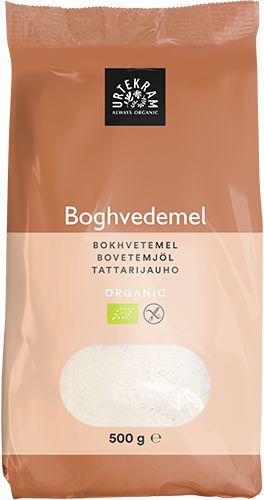 Urtekram Luomu Tattarijauho; 500 g:n pystyssä seisova suorakulmainen pakkaus mattapaperia vihrein tehostein, monikielinen merkintä ja läpinäkyvä ikkuna, josta näkyy jauho; etiketissä lihavoitua pääteviivatonta tekstiä, mm. paino ja tuotenimi; vaalea tausta, ei ihmisiä tai käsiä.