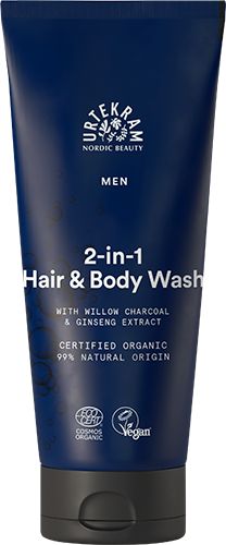 A blue tube of Urtekram Men 2-in-1 Hair & Body Wash with willow charcoal and ginseng extract, featuring certified organic and vegan labels, and made with 99% ingredients of natural origin. The tube is upright, has a matte finish, rounded cap, bold sans-serif white text for the product name, smaller text for details, and label icons visible. The background is plain white. No people or hands are present.