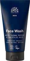 A blue, matte-finish plastic squeeze tube labeled “Urtekram Nordic Beauty Men Face Wash.” The front label in white, modern sans-serif font includes product name and mentions Tazman pepper and salicylic acid. Certifications and ingredient claims are highlighted. No people or hands. The background is plain white with even lighting in a frontal product shot.