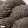 Close-up of several skeins of light brown, textured alpaca yarn with visible fibers. The yarn has a matte finish and is loosely wound into round skeins. A small label in the corner reads “hiekka,” which means sand in Finnish, indicating the color or shade of the yarn. Background appears neutral and plain. No people or hands visible in the image.