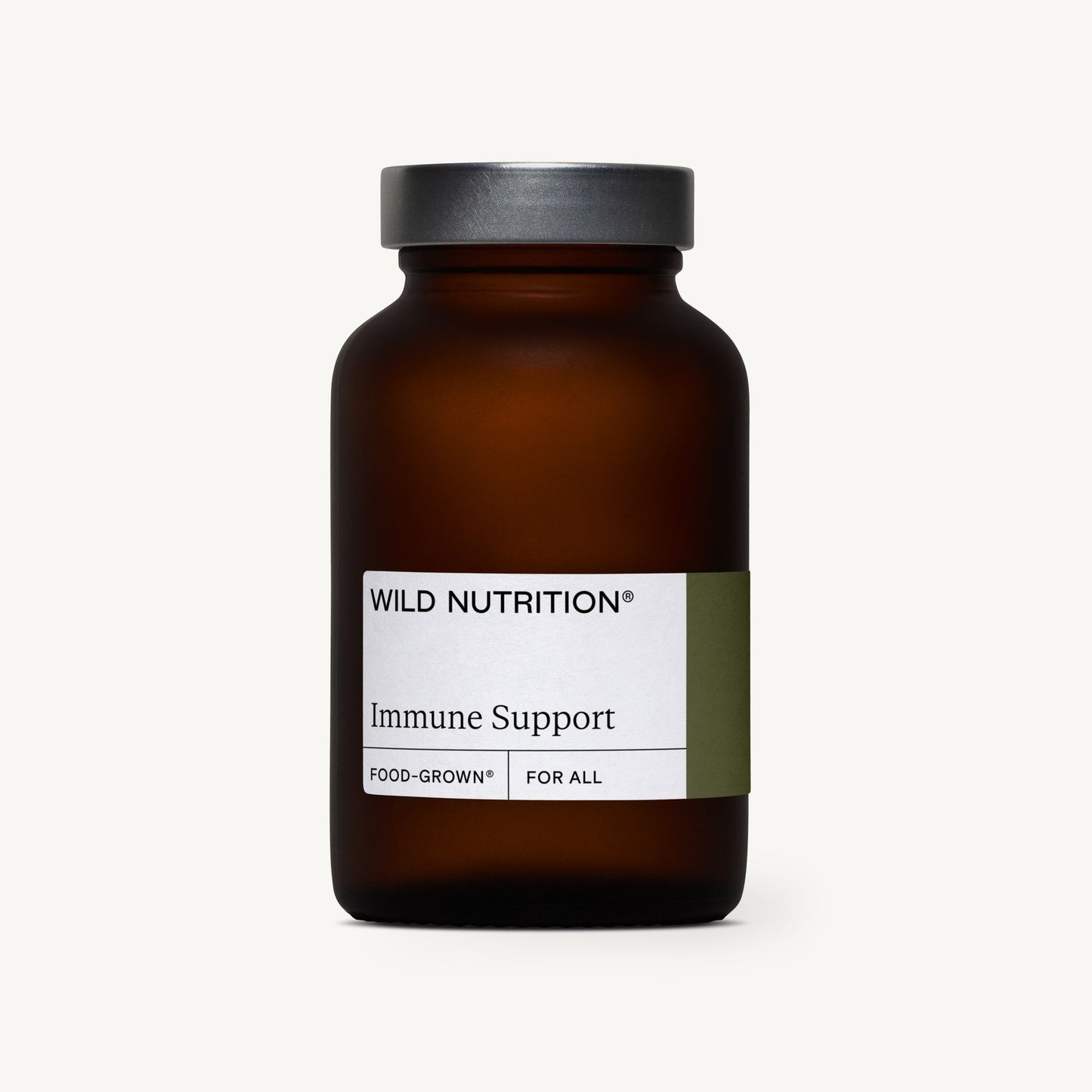 WILD NUTRITION Immune Support -pullo, ruskea lasipullo harmaalla kannella, kuvattu vaaleaa taustaa vasten; pullo sylinterimäinen mattapinnalla, valkoisessa etiketissä mustaa tekstausvapaata typografiaa sekä lisäteksti FOOD-GROWN ja FOR ALL; ei ihmisiä tai käsiä näkyvissä kuvassa.