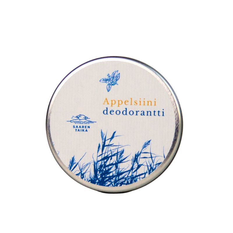 A round metal tin with a white matte-finish lid, labeled Appelsiini deodorantti. The lid displays illustrations of blue grass and a butterfly, the Saaren Taika logo, and an orange citrus graphic. Serif and sans-serif fonts are used in blue and gold. The product is photographed against a plain white background in a front-facing shot with no people or hands visible.