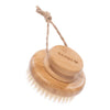 Round bamboo body brush with white bristles, a handle on top, and a looped rope attached. The engraved word BAMBU and a heart symbol are visible on the handle in uppercase block letters. The bamboo surface is matte. There is no packaging visible. The background is plain white. No people or hands are present in the image. This is a close-up product shot.
