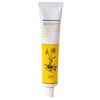 Bioearth The Herbalist Arnica Cream; valkoinen-keltainen, lieriön muotoinen ja mattapintainen tuubi, etusivulla kuvitus arnikkakasvista; musta ja vihreä groteskiteksti kertoo rauhoittavista kasviperäisistä ominaisuuksista; pystyssä valkoisella taustalla.