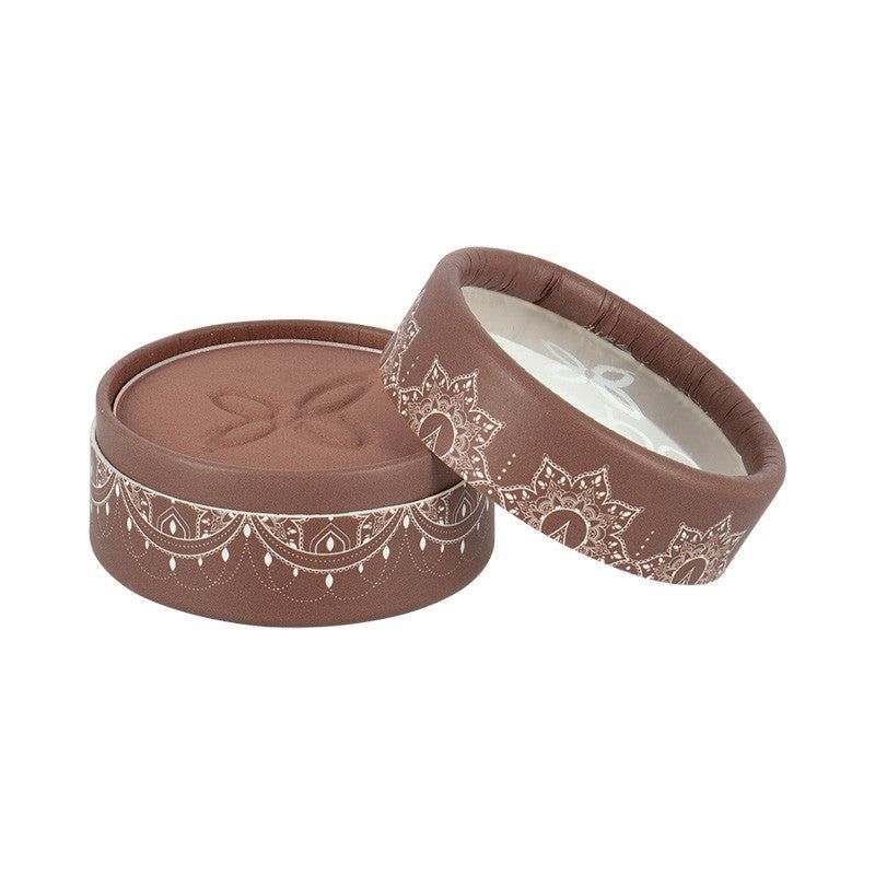 A round, brown box with a decorative white pattern and a partially open lid reveals a soft interior adorned with an intricate butterfly design. The box is matte and constructed from cardboard or similar material. No visible typography or legible text. It sits against a plain, neutral background in a close-up product shot. No people or hands are present.