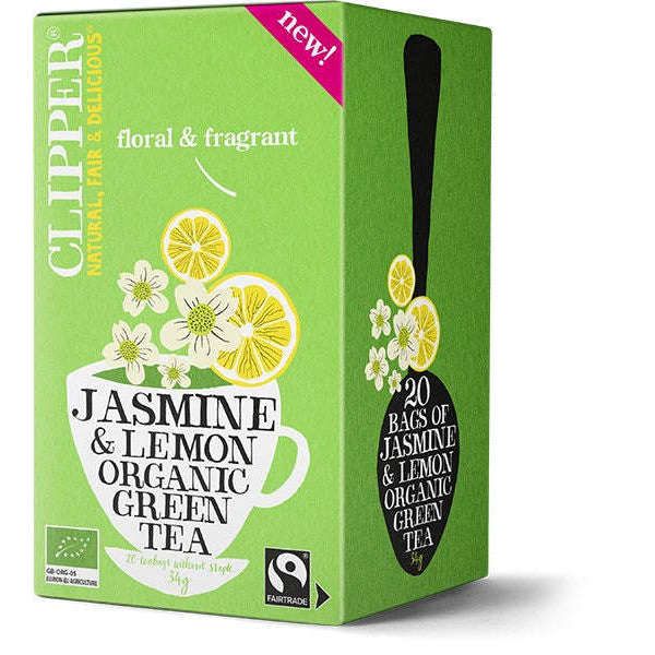 Clipper Luomu Vihreä Jasmiini & Sitruuna tee; vihreä suorakulmainen pahvilaatikko Clipper Jasmine & Lemon Organic Green Tea -teetä mattapintaisena; etupuolella litteitä kuvituksia valkoisesta teekupista, sitruunaviipaleista ja valkoisista jasmiinikukista; serifi- ja groteskikirjasin valkoisena ja keltaisena; pakkauksessa lukee "20 pussia" ja "kukkainen, tuoksuva sekoitus"; ei ihmisiä tai käsiä kuvassa, studiokuva pelkistetyllä taustalla.