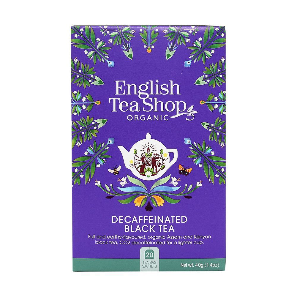 English Tea Shop Luomu Kofeiiniton Musta tee; violetti suorakulmainen mattapintainen pahvipakkaus, kuvituksena kukka- ja lehtikuvioita valkoisen, vihreän ja oranssin sävyissä; etupuolella valkoinen teekannukuvitus; groteskiteksti kertoo tuotteen olevan luomu ja kofeiiniton musta tee, sisältää 20 teepussia; vaalea tausta, ei ihmisiä tai käsiä kuvassa.