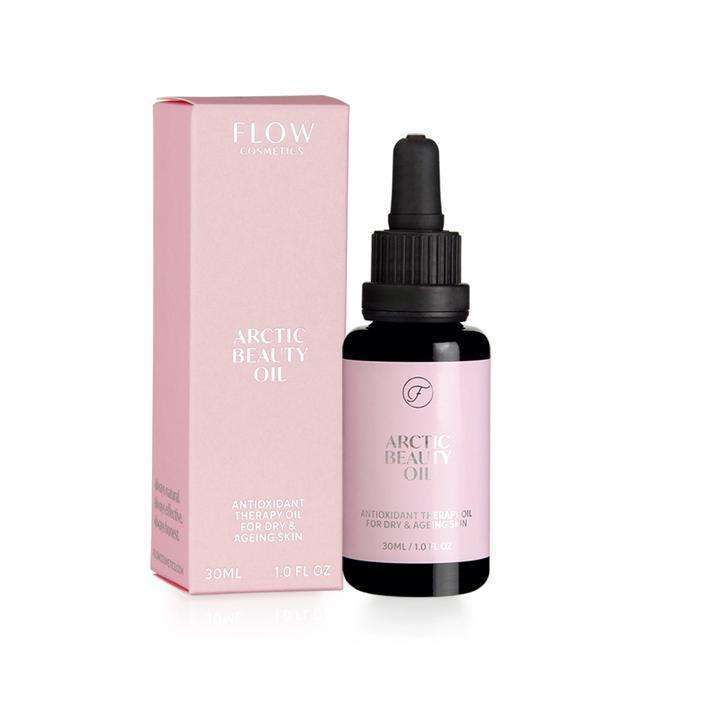 A pink box and a dropper bottle labeled Arctic Beauty Oil by Flow Cosmetics, described as antioxidant therapy oil for dry and aging skin, enriched with Nordic botanicals, 30ml size. The dropper bottle is transparent with a white cap; the label has clear sans-serif text. Both items are placed upright on a plain light background in a studio shot. No people or hands are visible.