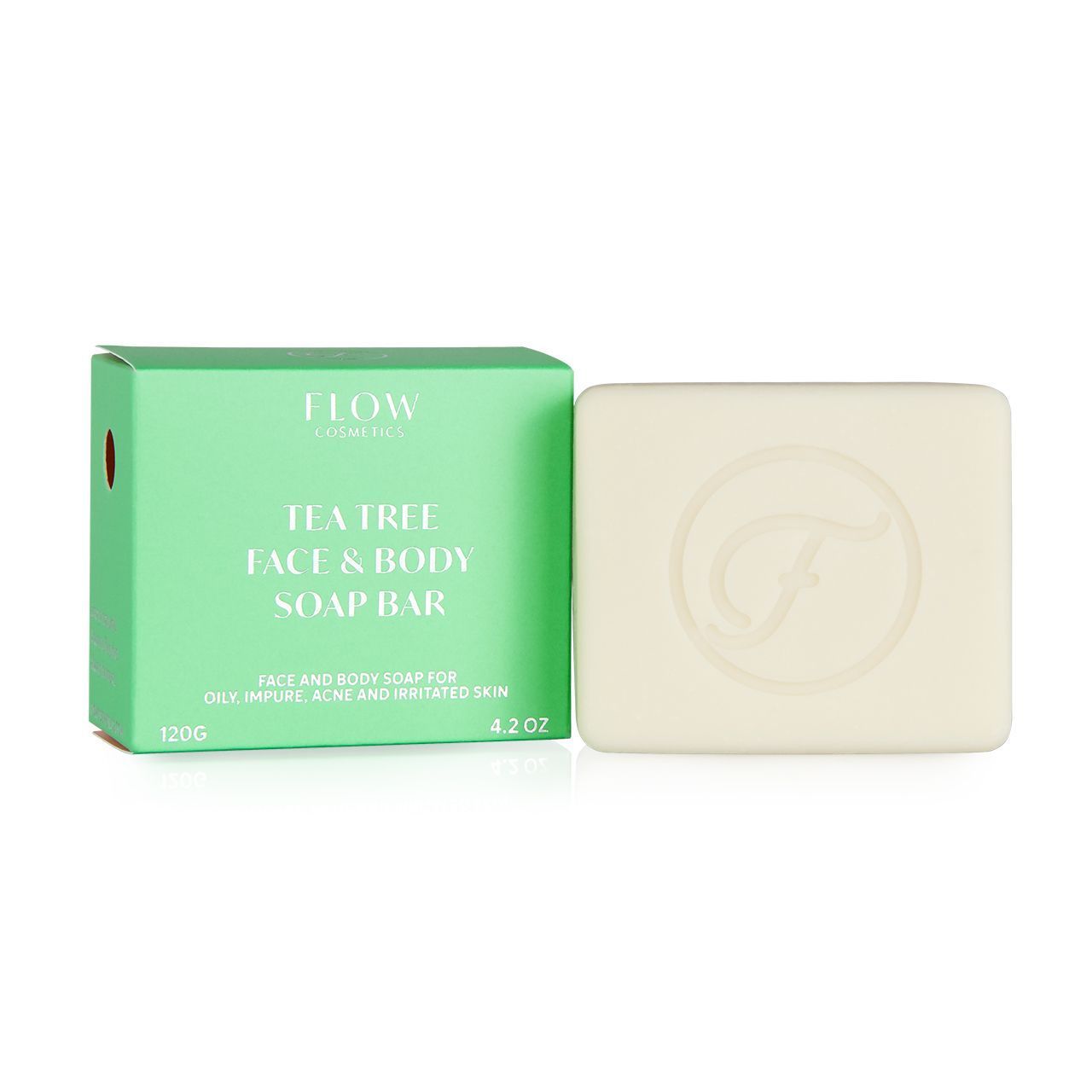 FLOW Cosmetics Tea Tree Kasvo- ja vartalosaippua; vihreä-valkoinen pahvipakkaus tekstillä "Flow Cosmetics Tea Tree Face & Body Soap Bar" vaalean, suorakulmaisen ja mattapintaisen saippuapalan vieressä, jossa kohokuvioitu kirjain F; minimalistista lihavoitua groteskitekstiä; vaalea tausta, tarkoitettu rasvoittuvalle ja aknealttiille iholle.