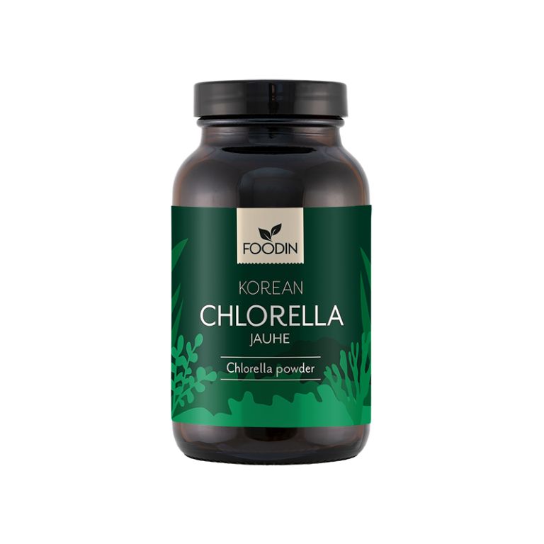 A dark cylindrical jar with a matte finish, labeled “Foodin Korean Chlorella Jauhe.” The label features green accents and leaf illustrations, with bold sans-serif text. The jar appears plastic and opaque. No people or hands are visible. The background is plain and neutral. A dark jar labeled Foodin Korean Chlorella Jauhe with green accents and leaf designs, containing nutrient-rich chlorella powder.