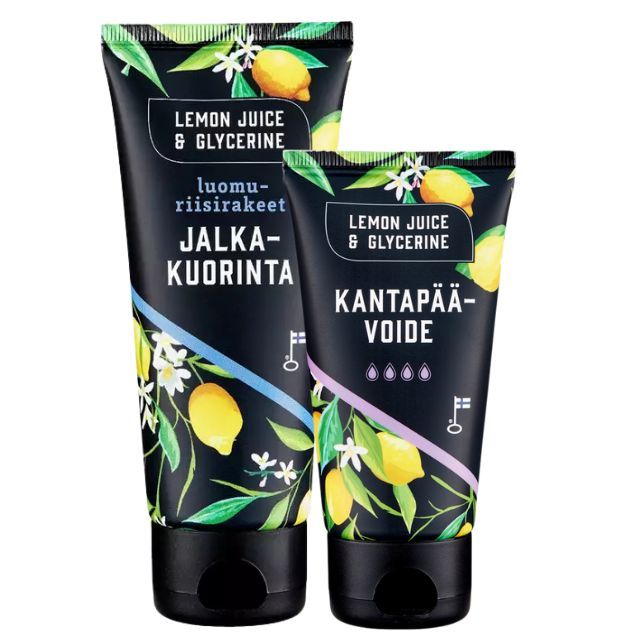 Lemon Juice & Glycerine Jalkahoito 2-pack; kaksi mustaa tuubia eloisin sitruuna- ja lehtikuvioin, merkitty Jalka-kuorinta ja Kantapää-voide; pakkaus muovia mattapinnalla ja selkeää modernia suomenkielistä typografiaa; ainesosina mainitaan Lemon Juice & Glycerine; tuubeissa läppäkannet, seisovat neutraalilla alustalla ilman ihmisiä tai käsiä.