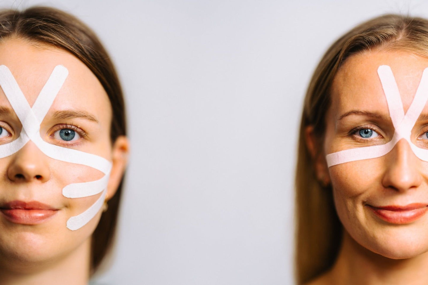 Two women with light skin face the camera, each with white tape strips arranged in geometric patterns on their faces. The woman on the left has more tape applied, and both are smiling slightly against a plain, light background. No product packaging or legible text is visible. No props or hands are shown, and the shot is taken from the front at head-and-shoulders level.
