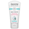 A tube of Lavera Basis Sensitiv moisturizing cream for dry skin, enriched with bio aloe vera and organic shea butter, featuring blue water splash artwork on a white background. The tube is white with a matte surface and features blue accents and simple sans-serif typography. The packaging shows the product name and ingredient highlights clearly on the front. No people or hands are visible. The product is photographed upright against a plain white backdrop in even lighting.