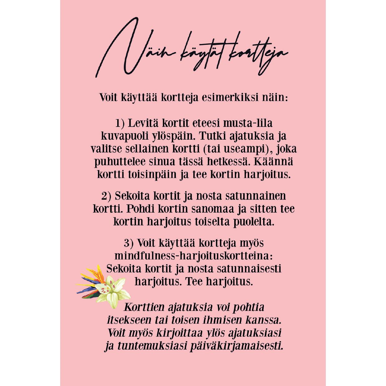 A pink card with Finnish text explaining three ways to use reflection cards, decorated with an illustration of two pastel flowers and green leaves at the bottom left corner—perfect for mindful moments or self-discovery exercises. The card has a rectangular shape, matte finish, and features sans serif black typography. No packaging or people are visible. The background is neutral and uncluttered. Photographed from above.