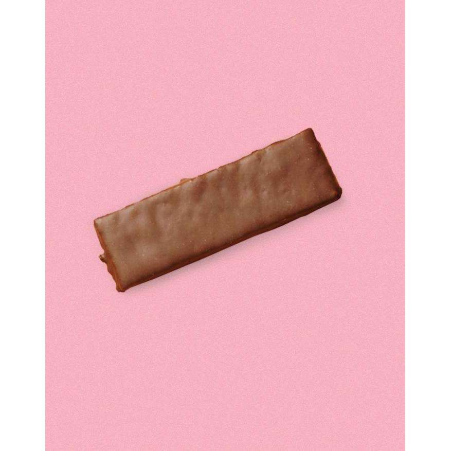 A single rectangular chocolate-covered biscuit is centered on a pink background, highlighting its glossy cocoa coating. The biscuit has smooth, straight edges and an even surface finish. There is no visible packaging, label text, or typography present in the image. The shot is taken from above with no people or hands included.