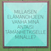 Hidasta Elämää Voimauttavat Kysymykset -kortit; turkoosi neliönmuotoinen kyltti tasaisesta mattamateriaalista kiinnitettynä yhtenäiselle vihreälle seinälle; pinnalla keskitettyä suomenkielistä tekstiä yksinkertaisella groteskifontilla; ei grafiikoita, logoja tai koristeita kyltissä; ei pakkausta tai kehystä näkyvissä; ei ihmisiä tai käsiä kuvassa; kyltti kehottaa pohtimaan, mitä neuvoja oma vanhempi itsensä antaisi nykyiselle itselle.